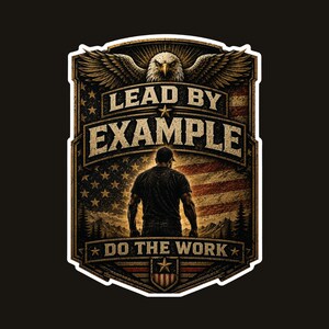 May include: A rectangular sticker featuring a bald eagle at the top, a silhouette of a person standing before an American flag, and the text "LEAD BY EXAMPLE" and "DO THE WORK" in a bold, distressed font with a shield-like border design.