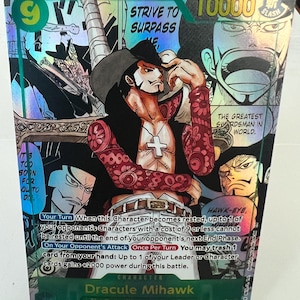 May include: A holographic trading card featuring Dracule Mihawk from "The Seven Warlords of the Sea." The card has a character illustration with the text "STRIVE TO SURPASS" and "THE GREATEST SWORDSMAN IN WORLD." The card also has game instructions.