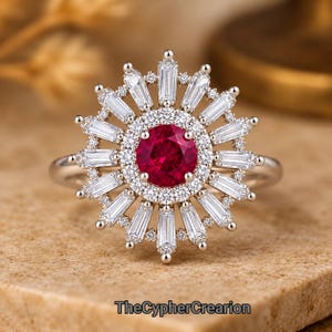 May include: A ring featuring a central round red gemstone surrounded by a halo of small round white stones. A sunburst design radiates outward with alternating baguette-cut white stones and small round stones. The text TheCypherCrearion is visible.