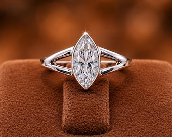 May include: A silver-toned ring featuring a large, marquise-cut clear gemstone set in a bezel setting. The band has a split-shank design that tapers toward the center stone. The text TheCypherCreation is printed at the bottom of the image.