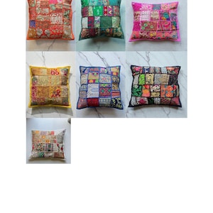 May include: A selection of decorative cushions with patchwork designs. The cushions display a variety of colours, including red, green, pink, yellow, blue, black, and white. Each cushion has a unique pattern, with a mix of textures and fabrics.