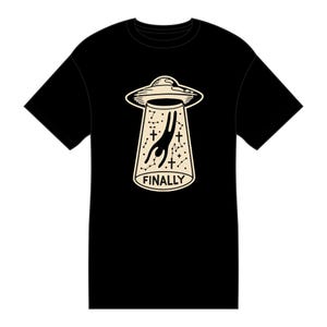 May include: A black short-sleeve t-shirt featuring a cream-colored graphic of a flying saucer abducting a figure. The beam contains constellations, small crosses, and the word FINALLY printed in a bold, sans-serif font at the bottom center.