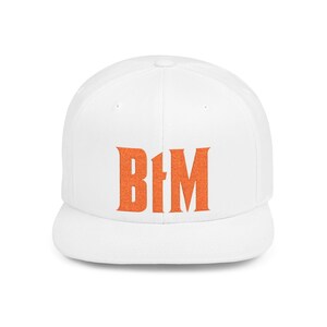 Puede incluir: Gorra de béisbol blanca con visera plana. La gorra presenta las letras naranjas "B1M" en la parte delantera. Un accesorio de estilo clásico, ideal para un look casual.