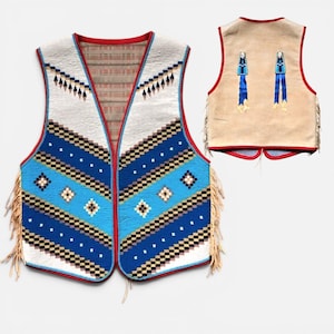 Peut inclure: Un gilet sans manches avec un motif géométrique dans des tons de bleu, blanc et noir avec une bordure rouge. Le devant présente un design texturé, tandis que le dos est en daim beige avec deux accents bleus et de longues franges sur les côtés.