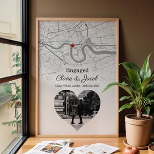 May include: Framed map print with a heart-shaped photo of a couple. The map shows a section of London with a red heart marking a location. Text reads "Engaged Claire & Jacob Canary Wharf, London - 28th June 2023."