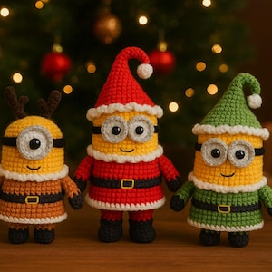 May include: Three crocheted Minion figures dressed in Christmas attire. One wears reindeer antlers, another a Santa suit, and the third a green elf outfit. They stand in front of a Christmas tree with lights and ornaments.