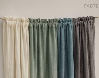 May include: A row of linen curtains in shades of cream, green, blue, and gray hang from a rope. The curtains are gathered at the top, creating soft folds. The FABTEXX logo is visible in the upper right corner.