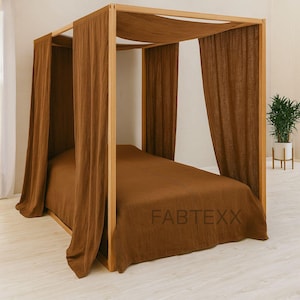 Può includere: Un letto a baldacchino in legno con tende e biancheria da letto in lino marrone. La struttura del letto è in legno chiaro e le tende e la biancheria da letto sono di un marrone caldo uniforme. Il testo "FABTEXX" è visibile sul copriletto.