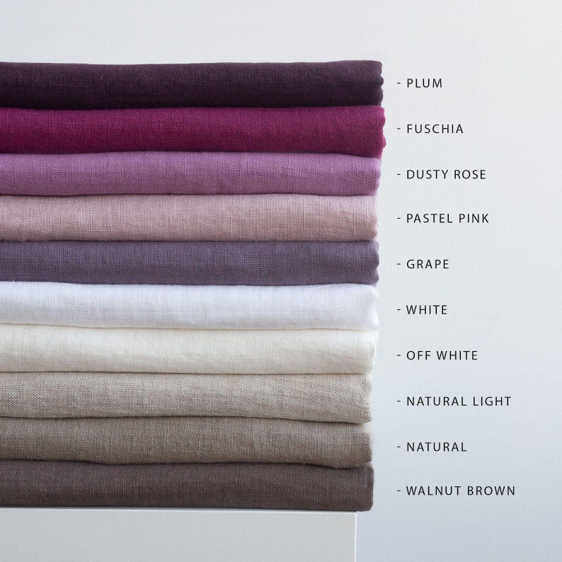 May include: A stack of linen fabric in various colors, including plum, fuchsia, dusty rose, pastel pink, grape, white, off-white, natural light, natural, and walnut brown. The colors are labeled on the right side of the image.