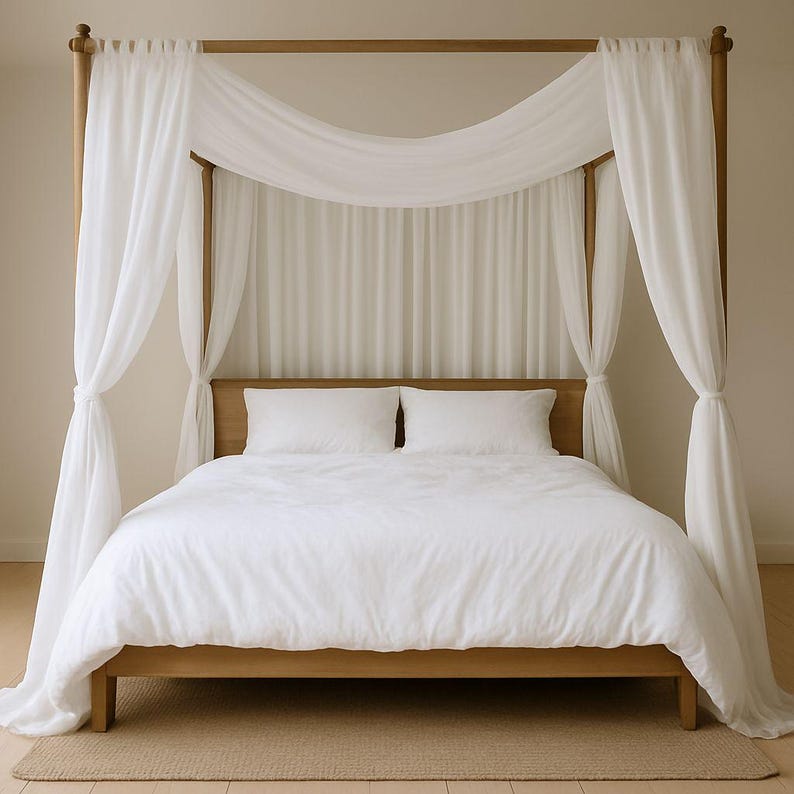 May include: A wooden four-poster bed with white bedding and sheer white curtains draped around the frame. The bed has a light brown wooden frame and a neutral-colored rug underneath.