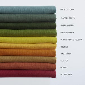 May include: A stack of folded fabric in various colors, including dusty aqua, safari green, dark green, moss green, chartreuse yellow, honey, mustard, amber, rusty, and berry red. Each color is labeled with its name.