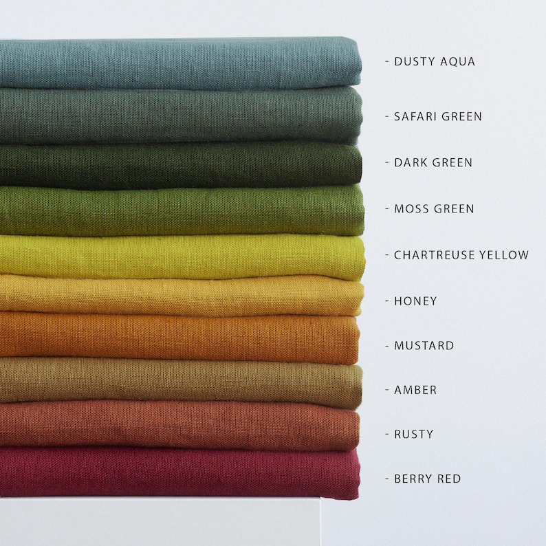May include: A stack of folded fabric in various colors, including dusty aqua, safari green, dark green, moss green, chartreuse yellow, honey, mustard, amber, rusty, and berry red. Each color is labeled with its name.
