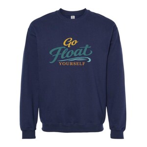 Peut inclure: Un sweat-shirt bleu marine à manches longues et col rond avec l'inscription Go Float Yourself imprimée sur la poitrine. Le mot Go est jaune, Float est en écriture cursive sarcelle et Yourself est jaune, avec une vague sarcelle sous le texte.