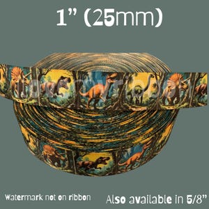 May include: A roll of 1-inch (25mm) wide ribbon featuring a repeating pattern of various dinosaurs in a forest setting. The ribbon has a dark teal, yellow, and orange color scheme. Text on the image reads "Watermark not on ribbon" and "Also available in 5/8".