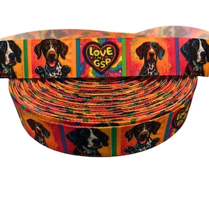 May include: A roll of colorful ribbon featuring German Shorthaired Pointers. The ribbon has a repeating pattern of dogs, hearts, and the text "Love My GSP" against a rainbow striped background. The ribbon is orange, red, yellow, and blue.