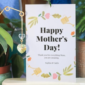 May include: A white card with a floral border and the text "Happy Mother's Day! Thank you for everything Mum, you are amazing, Sophia & Caleb".