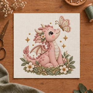 Puede incluir: Un lienzo cuadrado con un dragón de color rosa claro con escamas texturizadas, sentado entre hojas verdes y flores blancas. Una mariposa vuela cerca de la cabeza del dragón, rodeada de pequeñas estrellas doradas sobre un fondo de tela color crema.