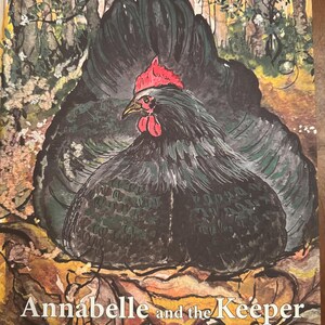May include: A painting of a black chicken with a red comb and wattle sitting on a nest of brown leaves. The background features a forest with trees and white flowers. The text "Annabelle and the Keeper" is printed in white at the bottom.