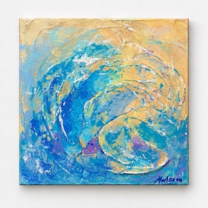 Op de afbeelding: Een vierkant schilderij op canvas met een abstract golfontwerp met dikke, getextureerde impasto penseelstreken in tinten helderblauw, turkoois, wit en goudgeel. De rechterbenedenhoek bevat een handtekening in donkerblauwe inkt.