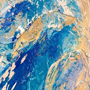 May include: An abstract painting on canvas featuring thick, textured impasto brushstrokes in shades of deep blue, bright turquoise, and sandy beige. The surface displays a layered, three-dimensional quality with prominent white paint accents.