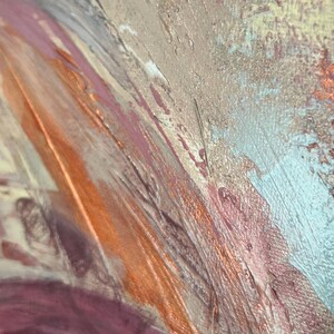 May include: An abstract painting featuring thick, textured layers of paint in shades of copper, metallic gold, dusty rose, and soft white. The surface displays visible brushstrokes and palette knife marks, creating a dynamic, layered composition.