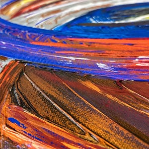 May include: An abstract painting on canvas featuring thick, textured impasto brushstrokes in vibrant shades of royal blue, bright orange, deep brown, and white. The composition displays swirling, layered paint application with visible ridges.