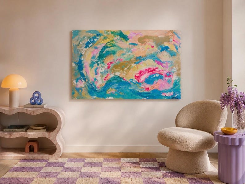 May include: A large rectangular abstract painting featuring swirling layers of teal, bright pink, gold, and soft peach paint. The artwork displays thick, textured brushstrokes and fluid, organic shapes that create a vibrant, multi-colored composition.