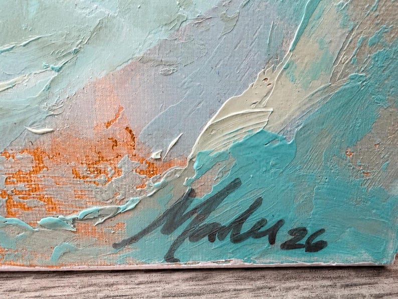 May include: An abstract oil painting on canvas featuring thick, textured impasto brushstrokes in shades of turquoise, cream, and muted orange. The bottom right corner displays a dark, handwritten signature that reads Malu followed by the number 26.