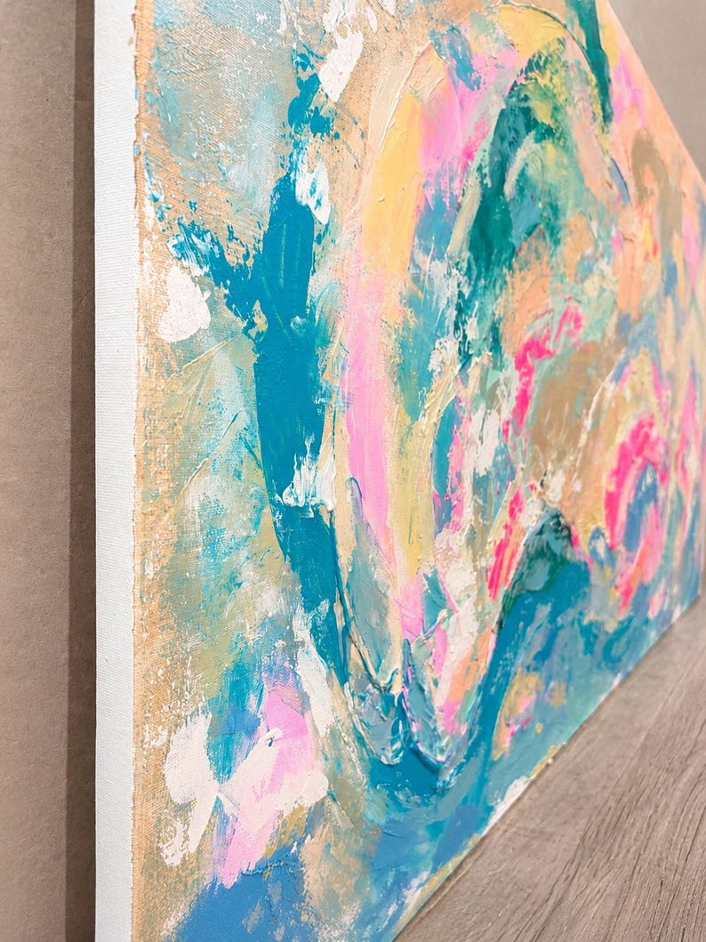 May include: An abstract painting on canvas featuring thick, textured layers of paint in vibrant shades of turquoise, bright pink, soft yellow, and metallic gold. The composition displays swirling, energetic brushstrokes and palette knife marks.