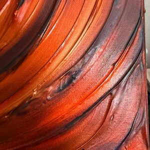 May include: An abstract painting on canvas featuring thick, textured brushstrokes in shades of orange, red, and deep brown. The paint is applied in sweeping, curved lines across the surface. The signature "Malu 26" is visible in the bottom corner.