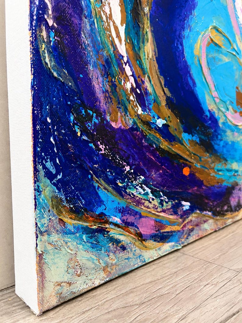 May include: An abstract painting on a rectangular canvas featuring thick, textured layers of acrylic paint in shades of deep navy blue, bright turquoise, metallic gold, and soft pink, with visible brushstrokes and impasto techniques throughout.