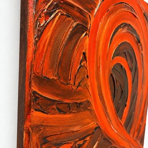 May include: An abstract painting on canvas featuring thick, textured impasto brushstrokes in shades of deep brown and vibrant orange. The composition displays swirling, circular patterns that create a sense of movement across the surface.