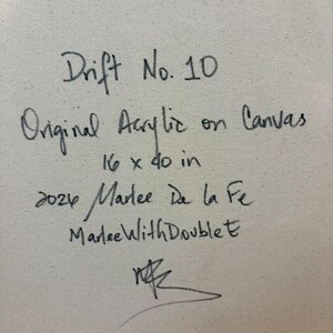 May include: A textured off-white canvas surface featuring handwritten black ink text that reads: Drift No. 10, Original Acrylic on Canvas, 16 x 40 in, 2024 Marlee De la Fe, MarleeWithDoubleE, and a stylized signature at the bottom.