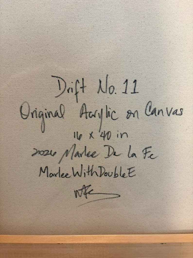May include: A beige canvas surface featuring black handwritten text that reads: Drift No. 11, Original Acrylic on Canvas, 16 x 40 in, 2026, Marlee De la Fe, Marlee With Double E, and a stylized signature at the bottom.