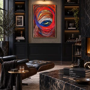 May include: A rectangular abstract painting featuring swirling, thick brushstrokes in vibrant shades of red, orange, and deep blue, framed in a thin gold border and mounted on a dark wall above a black leather lounge chair and a marble coffee table.