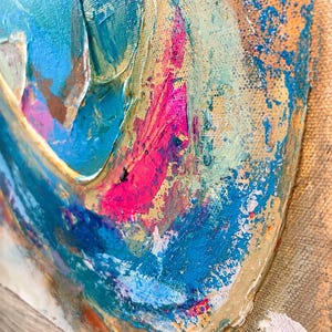 May include: An abstract painting on canvas featuring thick, textured layers of acrylic paint. The composition displays vibrant shades of turquoise, bright pink, and deep blue, contrasted against a neutral, sandy beige background with visible brushstrokes.