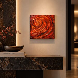 May include: A square canvas painting featuring thick, textured impasto brushstrokes in shades of deep red, orange, and black, creating a swirling, vortex-like pattern that dominates the composition with high-contrast color depth.