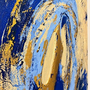 May include: An abstract painting on canvas featuring thick, textured layers of deep royal blue, light sky blue, and metallic gold paint. The composition displays swirling, curved brushstrokes and heavy impasto applications of gold.