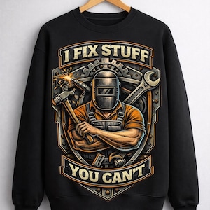 May include: Black sweatshirt with a graphic featuring a welder wearing a mask, holding a hammer, and the text "I FIX STUFF YOU CAN'T". The design includes a wrench and gear elements.