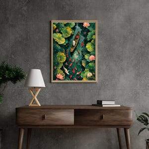 Op de afbeelding: Ingelijste kunstdruk met een boot op een vijver met waterlelies, koikarpers en lotusbloemen. Het kunstwerk toont een persoon in een boot, omringd door groen en kleuren, wat een rustige sfeer creëert. De lijst is lichtbruin.