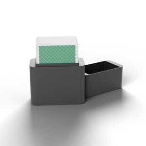 Könnte beinhalten: Ein Kartenspiel mit grün-weißem Rautenmuster auf der Rückseite, das teilweise in einer dunkelgrauen, rechteckigen Aufbewahrungsbox steckt. Ein passender dunkelgrauer Deckel liegt horizontal rechts neben dem Hauptbehälter.