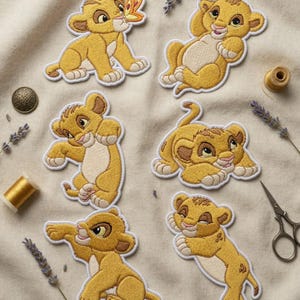 Könnte beinhalten: Gestickte Aufnäher mit einem Löwenjungen-Cartoon in verschiedenen Posen. Die Aufnäher sind hauptsächlich gelb und hellbraun mit weißen Rändern. Ein Aufnäher zeigt einen Schmetterling. Weitere Artikel sind ein Knopf, Garnrollen, Lavendelzweige und eine Schere.