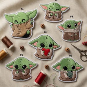 May include: A collection of six embroidered patches depicting a green alien character. Each patch shows the character in different poses, wearing a brown cloak. The patches are numbered and include a heart and a frog. Measurements are in cm.