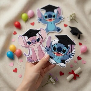 May include: Three embroidered patches featuring the characters Stitch and Angel from Lilo & Stitch, wearing graduation caps. The patches are blue and pink, with black caps. Decorative elements include miniature balloons, hearts, and a rolled diploma.