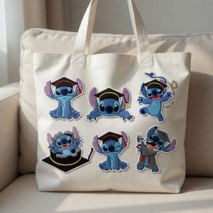 May include: A cream-colored tote bag featuring six blue Stitch character patches, each wearing a graduation cap. The patches depict Stitch in various poses, celebrating graduation. The bag has two handles and is sitting on a beige couch.