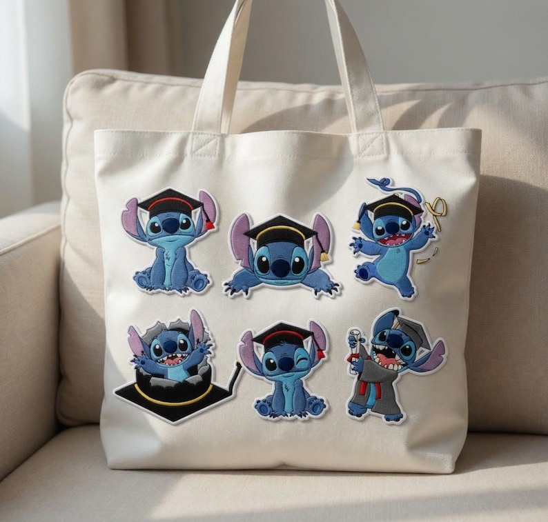 May include: A cream-colored tote bag featuring six blue Stitch character patches, each wearing a graduation cap. The patches depict Stitch in various poses, celebrating graduation. The bag has two handles and is sitting on a beige couch.