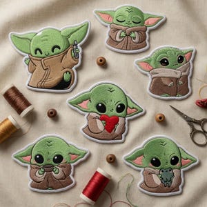 May include: Embroidered patches of a green alien character in different poses. The patches show the character holding a small device, a red heart, and a frog. Sewing supplies, including thread spools and wooden beads, surround the patches.
