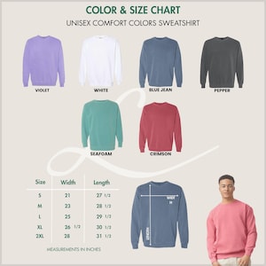 K&ouml;nnte beinhalten: Farb- und Gr&ouml;&szlig;entabelle f&uuml;r Unisex-Sweatshirts in Komfortfarben. Die Tabelle zeigt Sweatshirts in Violett, Wei&szlig;, Blue Jean, Pfeffer, Seafoam und Crimson. Ma&szlig;e in cm sind f&uuml;r die Gr&ouml;&szlig;en S, M, L, XL und 2XL angegeben, mit einer Breite von 53,3 bis 71,1 cm und einer L&auml;nge von 69,9 bis 80 cm.