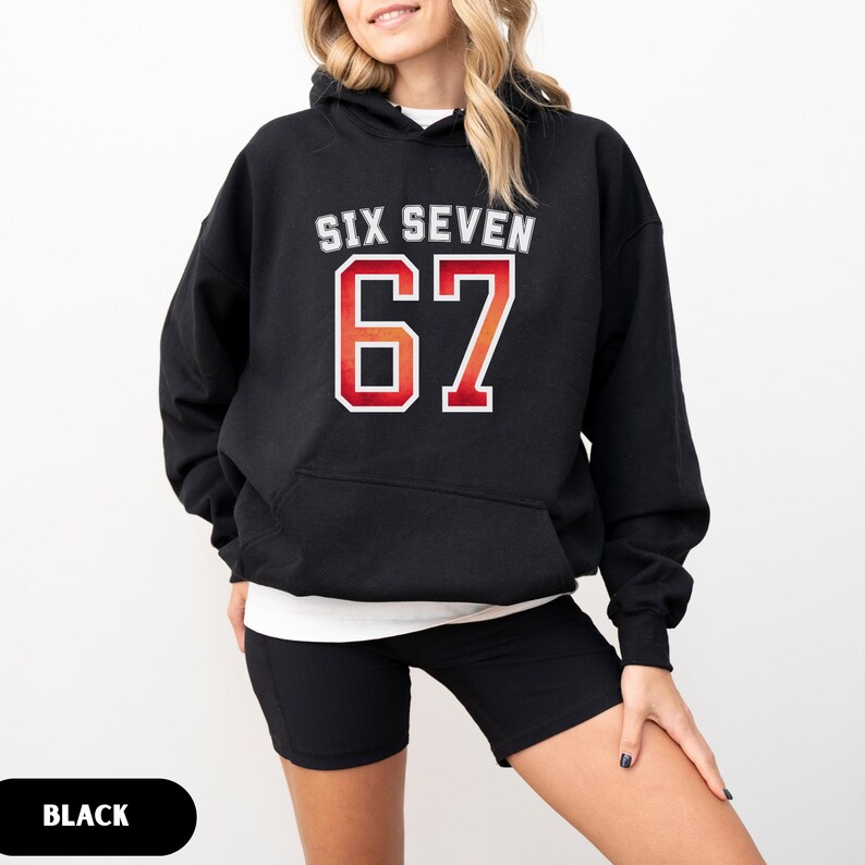 May include: Black hoodie with the text "SIX SEVEN" above the number "67" in a red and orange gradient. The hoodie has a white outline around the text and numbers. The word "BLACK" is in a black oval at the bottom of the image.