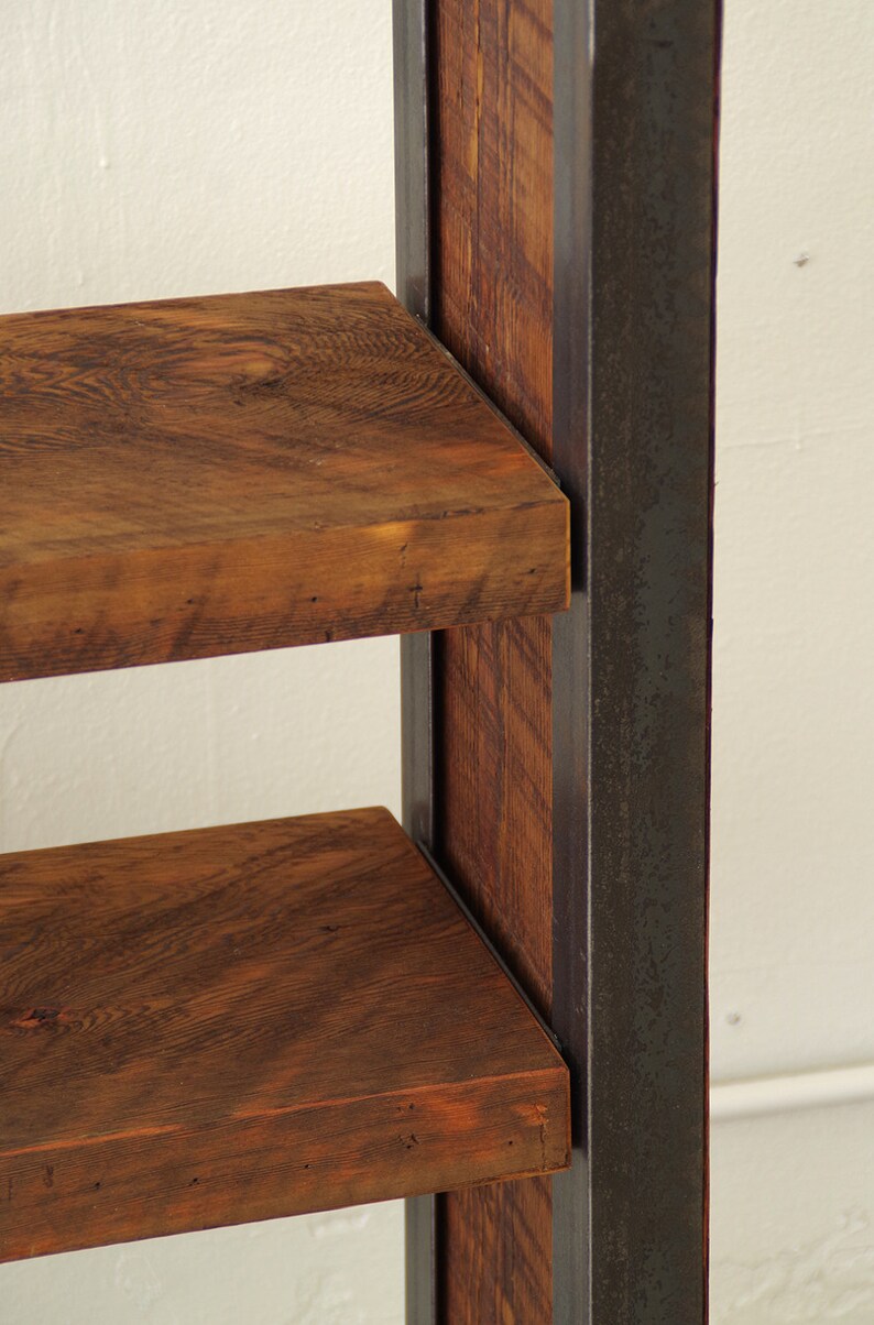 May include: A wooden shelf unit with two shelves, supported by a black metal frame. The shelves are made of reclaimed wood with a natural brown finish.